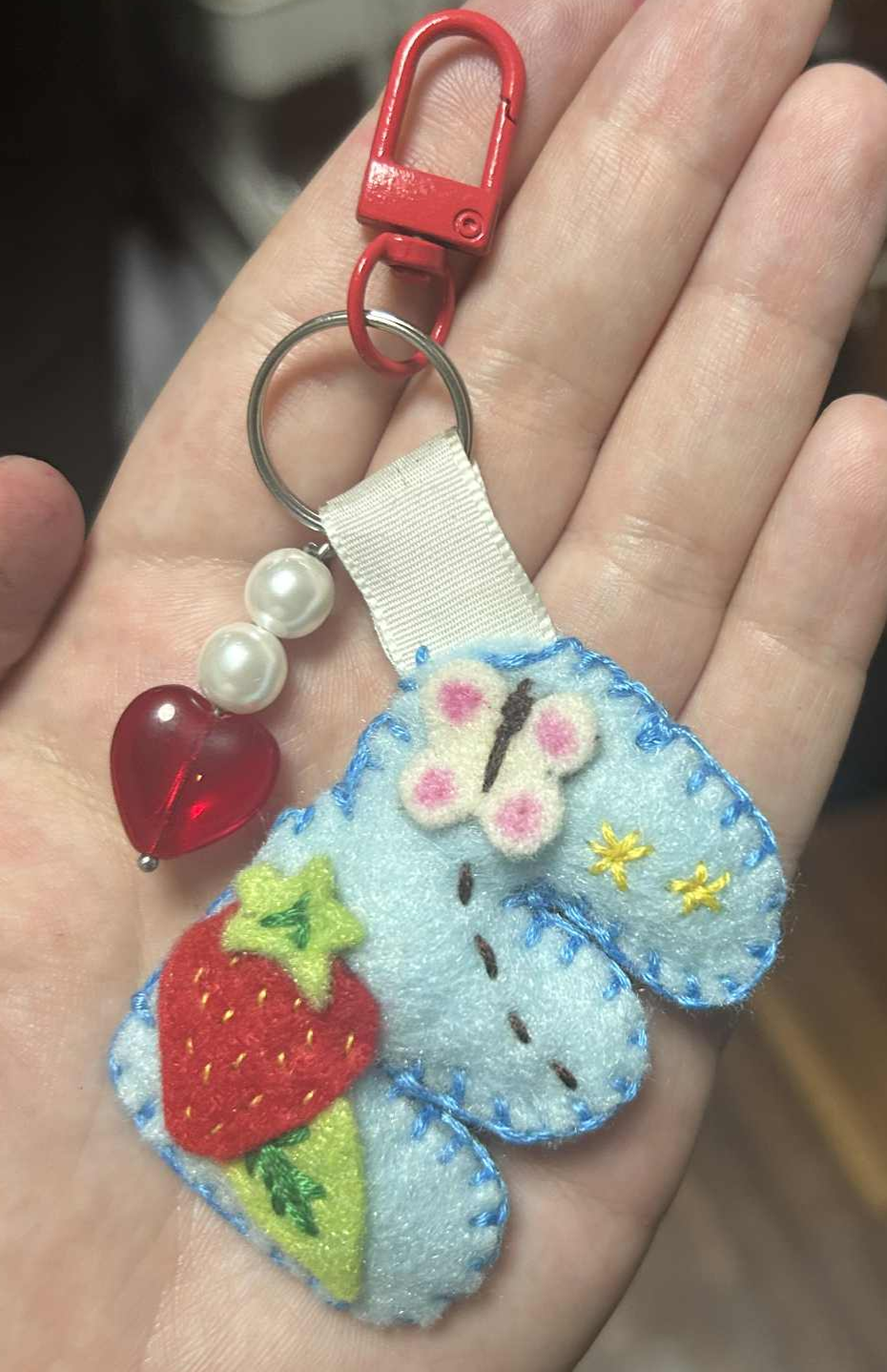 Chunky blue fabric letter E decorated with a strawberry, leaves, a white butterfly, and embroidered stars.